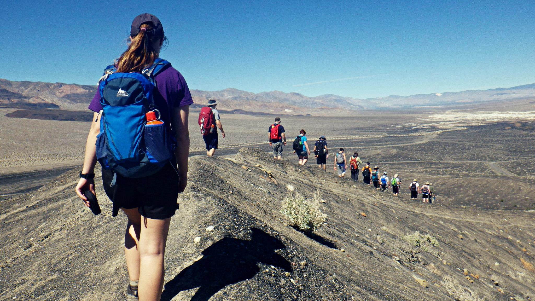 Students hiking along a ridge line down into Death Valley